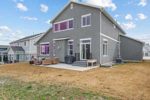 Rear view of property featuring fence, an outdoor living space, a patio area, and a yard