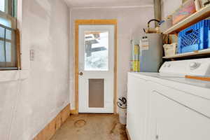 Washroom featuring independent washer and dryer, gas water heater, and laundry area