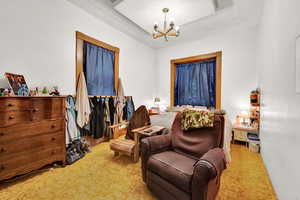 Bedroom featuring light carpet and an inviting chandelier