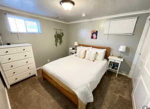Bedroom with baseboards, a textured ceiling, ornamental molding, and dark carpet