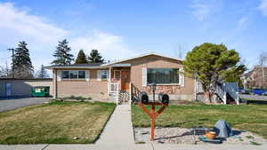 Bungalow-style house with a front yard and brick siding