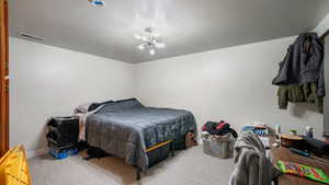 Carpeted bedroom with an inviting chandelier, baseboards, and visible vents