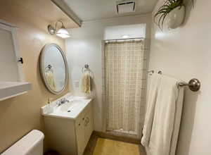 Full bath with tile patterned flooring, vanity, toilet, a shower with shower curtain, and visible vents