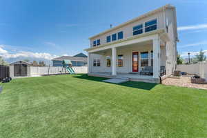 Fully fenced turf backyard with a shed, and a playground