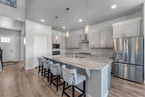 Kitchen featuring a sink, stainless steel appliances, tasteful backsplash, and light wood-style floors