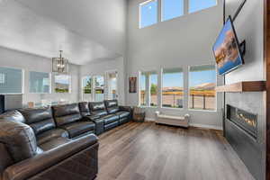 Living area with a wealth of natural light, a towering ceiling and a glass covered gas fireplace