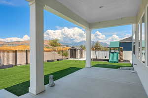 Fully fenced turf backyard with a shed, and a playground