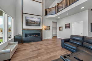 Living area with a wealth of natural light, a towering ceiling and a glass covered gas fireplace