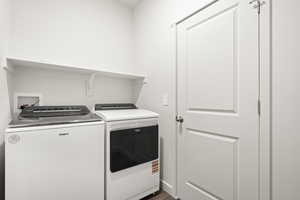 Laundry room featuring washer and clothes dryer and wood finished floors