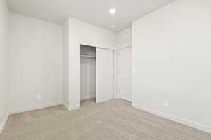 Unfurnished bedroom featuring carpet, baseboards, a closet, and recessed lighting