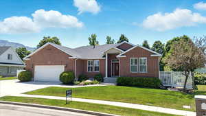 View of front facade featuring an attached garage, brick siding, driveway, and a mountain view