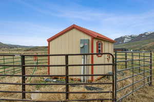 View of outdoor structure featuring an exterior structure, an outbuilding, a mountain view, and a rural view