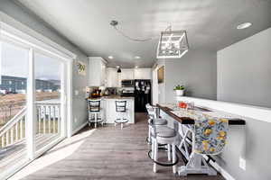 Kitchen with light wood-style flooring, a peninsula, stainless steel appliances, recessed lighting, and white cabinetry
