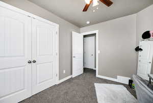 Unfurnished bedroom featuring baseboards, visible vents, a closet, and dark carpet
