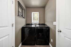 Laundry room featuring washer and clothes dryer, baseboards, laundry area, and a textured ceiling