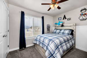 Carpeted bedroom featuring baseboards, ceiling fan, and visible vents