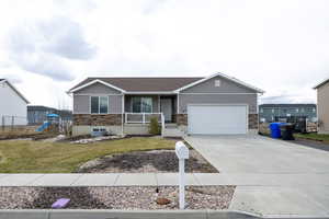 Ranch-style house with concrete driveway, a front lawn, covered porch, a playground, and a garage