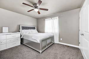 Unfurnished bedroom featuring baseboards, carpet floors, visible vents, and a ceiling fan