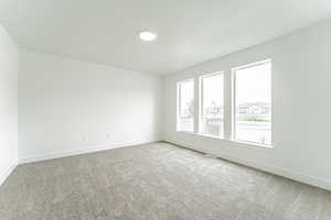 Carpeted spare room with baseboards