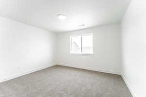 Empty room featuring carpet floors and a textured ceiling