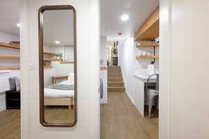 Hallway with dark wood-type flooring, stairway, and recessed lighting