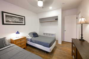 Bedroom with wood finished floors, a ceiling fan, and a closet