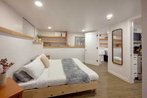 Bedroom featuring wood finished floors, a walk in closet, and recessed lighting