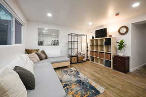 Living area featuring wood finished floors and recessed lighting