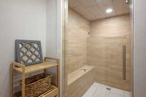 Bathroom with a tile shower, recessed lighting, and light tile patterned floors