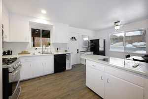 Kitchen featuring black appliances, white cabinets, dark wood-type flooring, recessed lighting, and tasteful backsplash