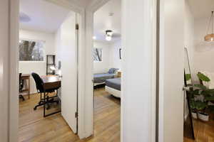 Corridor with a desk and light wood-style flooring