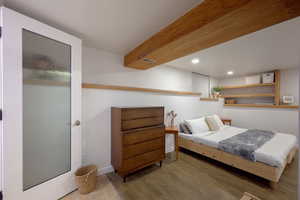 Bedroom with wood finished floors, recessed lighting, and beamed ceiling