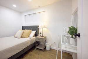 Bedroom with wood finished floors and recessed lighting