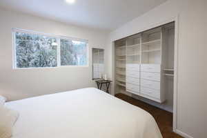 Bedroom featuring dark wood-style floors and a closet
