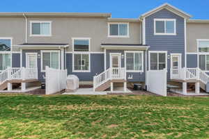 Back of house featuring stucco siding, central AC unit, and a yard