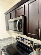 Room details featuring dark brown cabinets and stainless steel appliances