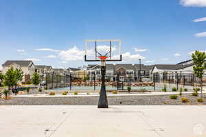 View of basketball court with a residential view and fence