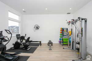 Workout area featuring baseboards, visible vents, recessed lighting, and wood finished floors