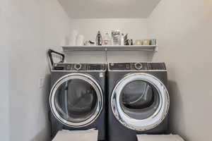 Clothes washing area featuring independent washer and dryer and laundry area