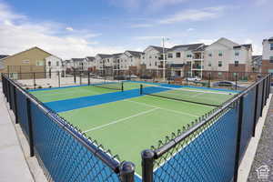 View of tennis court featuring a residential view and fence