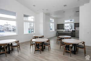 Dining room featuring baseboards, high vaulted ceiling, visible vents, and light wood-type flooring