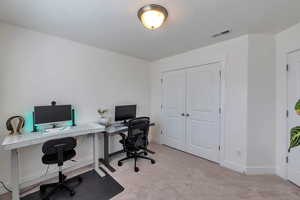 Carpeted office space with visible vents and baseboards