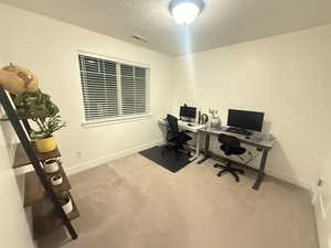 Office featuring visible vents, carpet, baseboards, and a textured ceiling