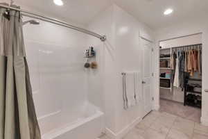 Bathroom featuring recessed lighting, baseboards, a walk in closet, and shower / bath combination with curtain