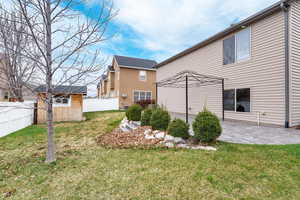 Back of property featuring fence, a yard, and a patio