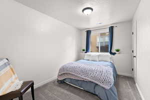 Bedroom featuring baseboards, visible vents, carpet floors, and a textured ceiling