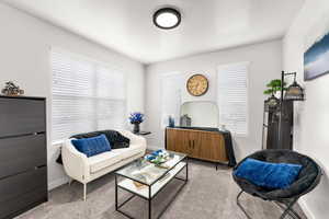 Living room with baseboards, carpet flooring, and a textured ceiling