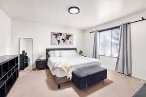 Bedroom with baseboards, visible vents, carpet floors, and a textured ceiling