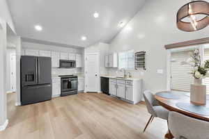 Kitchen with light countertops, recessed lighting, a sink, light wood-style flooring, and black appliances