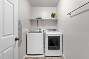 Laundry room featuring separate washer and dryer, baseboards, and laundry area